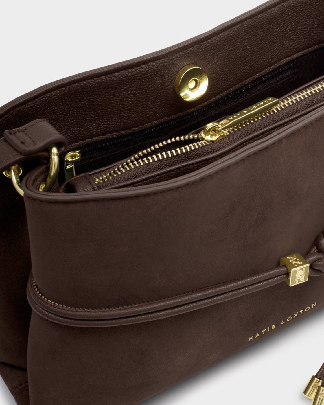 Lori Suedette Crossbody Bag in Bitter Chocolate with brown faux suede, gold zippers, magnetic snap closure, “Katie Loxton” in gold on front, and adjustable strap; available in one size.