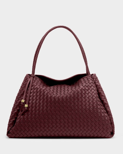 The Nova Hand Woven Large Shoulder Bag in Cherry features intricately woven vegan leather, a braided handle, and two leather tassels. Available in large size.