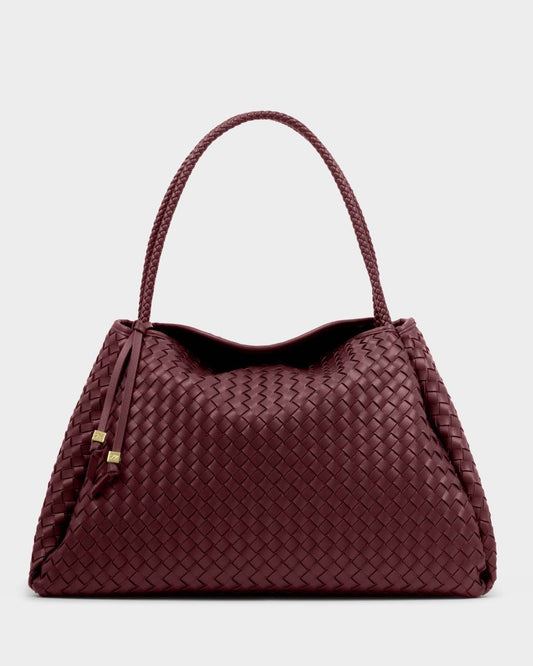 The Nova Hand Woven Large Shoulder Bag in Cherry features intricately woven vegan leather, a braided handle, and two leather tassels. Available in large size.
