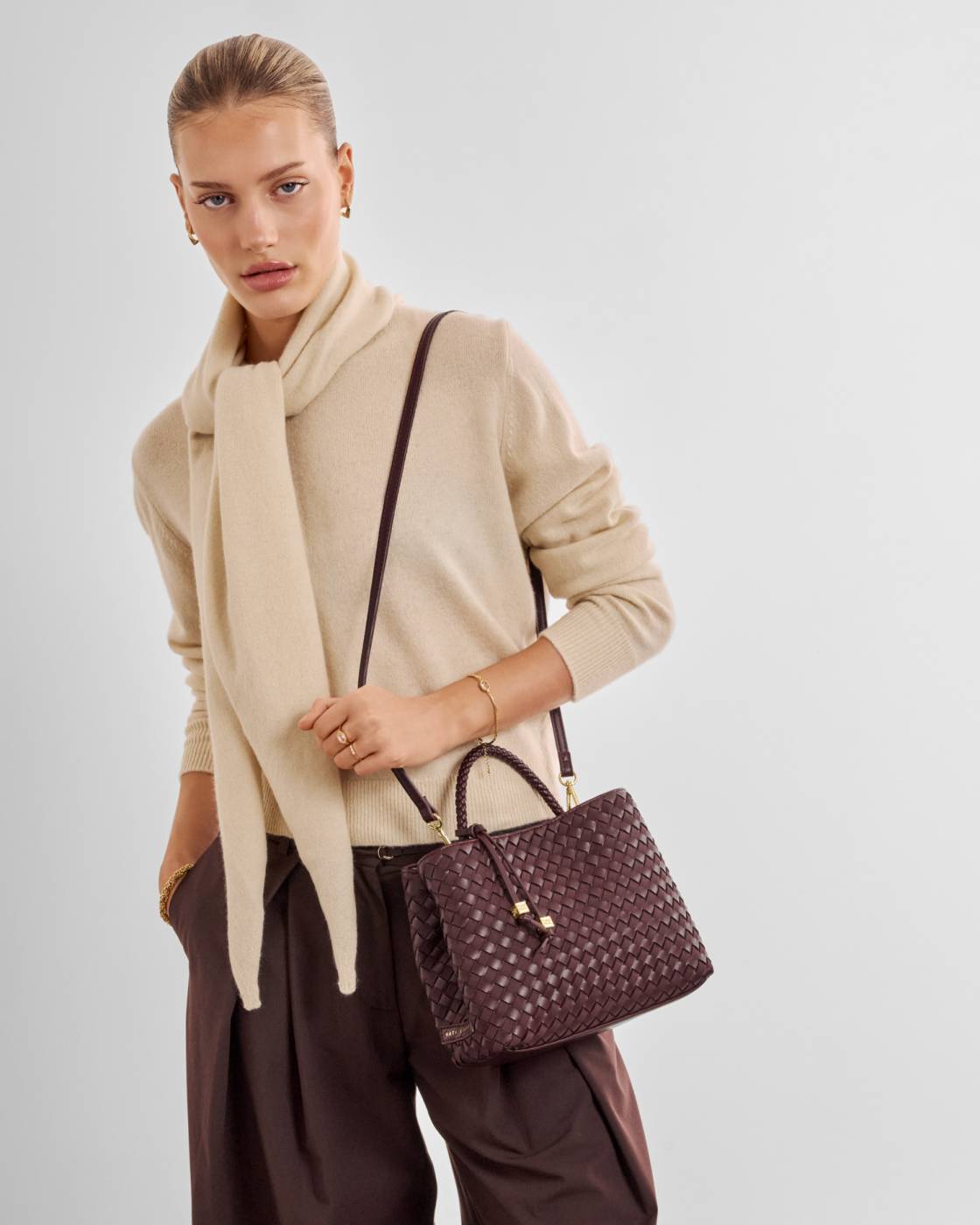 Nova Hand Woven Top Handle Bag in Cherry with crossbody strap, available in small and medium sizes.