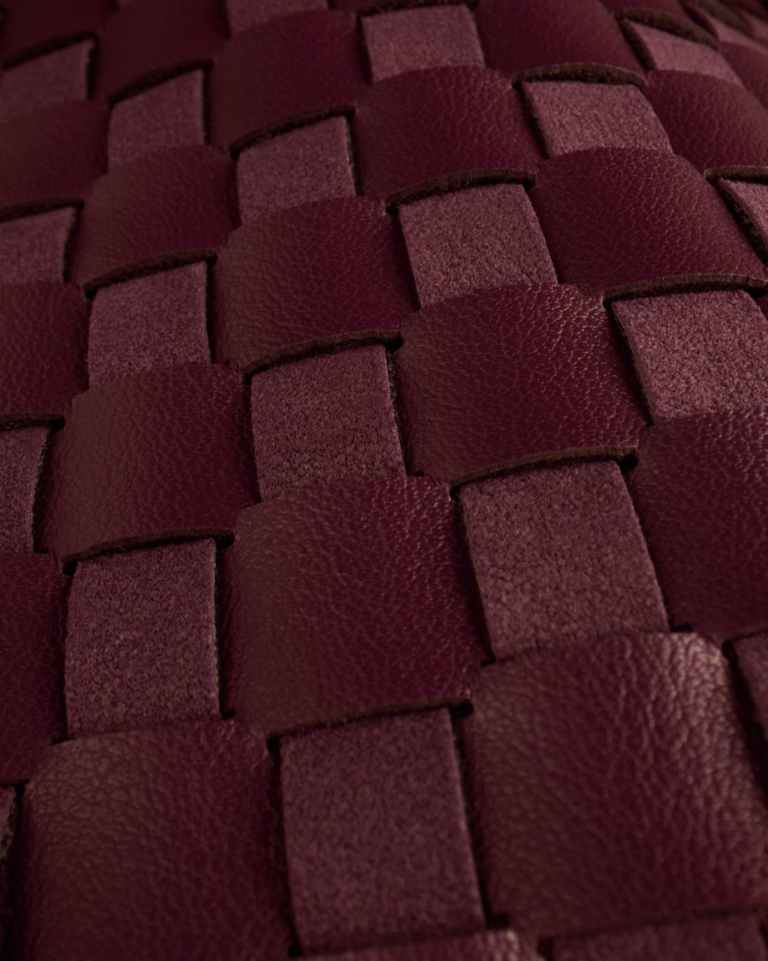 Close-up of interwoven cherry vegan leather strips in a basket weave pattern on the Nova Hand Woven Top Handle Bag | Cherry. Available in small and medium sizes.