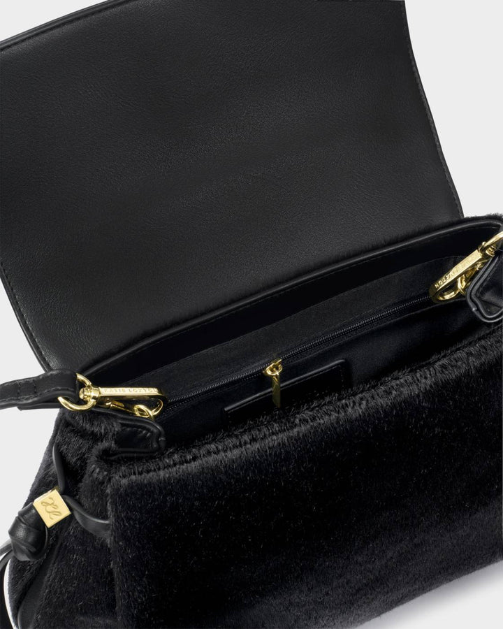 Alyssa Faux Pony Top Handle Bag in black with gold zipper and hardware. Suede-like vegan leather exterior, leather interior, spacious main compartment, zippered pocket, and crossbody strap. Sizes available: Small, Medium.