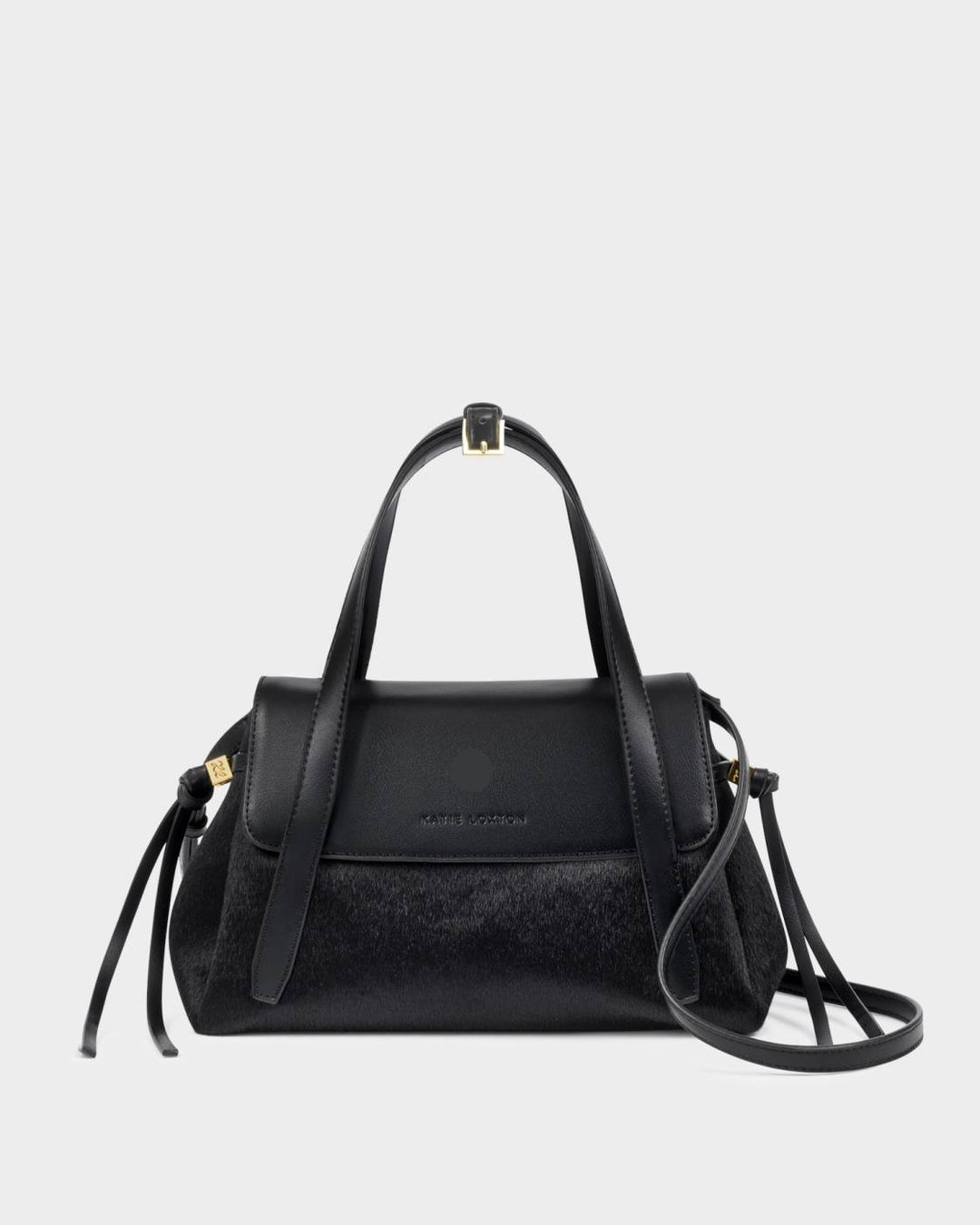 Alyssa Faux Pony Top Handle Bag in black faux pony hair and leather with gold hardware, top handle, detachable crossbody strap, flap closure, and side tassel details. Sizes available: [insert sizes].