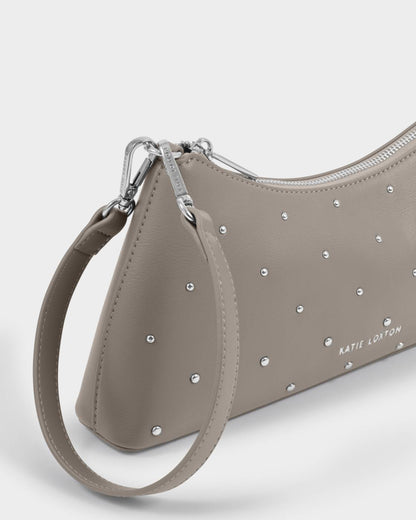 Silver Mink-colored Miley Studded Small Shoulder Bag in studded vegan leather with silver studs and hardware, wrist strap, and “KATIE LOXTON” embossed on the front. Available in small size.