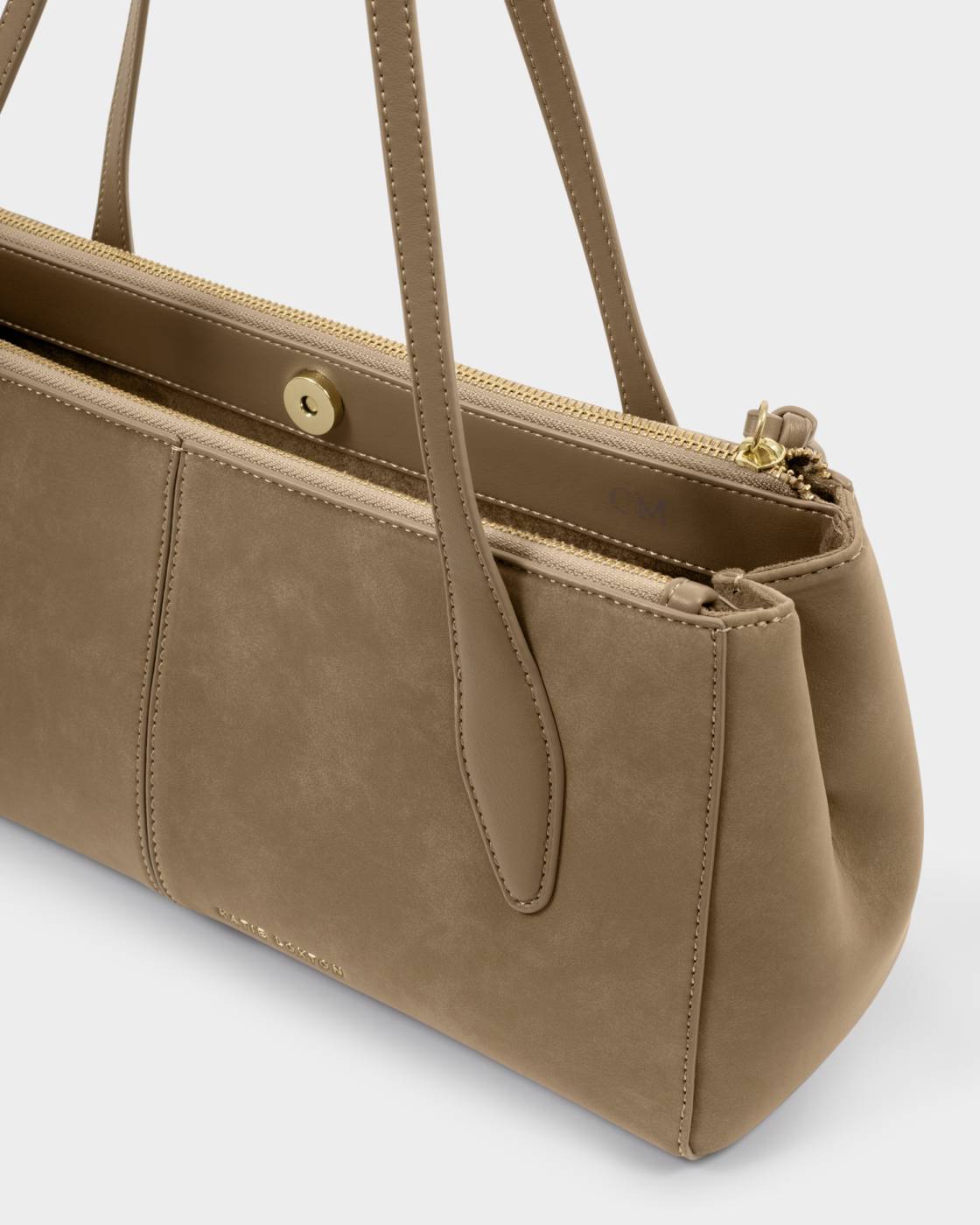 Hattie Suedette Shoulder Bag in taupe vegan suede with two handles, magnetic snap closure, gold zipper, prominent stitching, and side pocket. Available in one size.