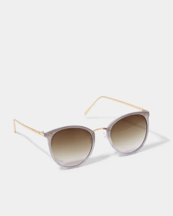 The Santorini Sunglasses have round light gray frames, gold arms, gradient brown UV400 lenses; available in multiple sizes.