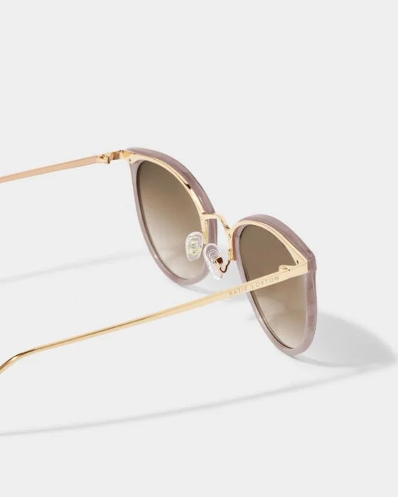 Pale pink cat-eye Santorini Sunglasses, gold arms, brown gradient lenses, UV400, "KATIE LOXTON" logo. Sizes: S/M/L/XL.