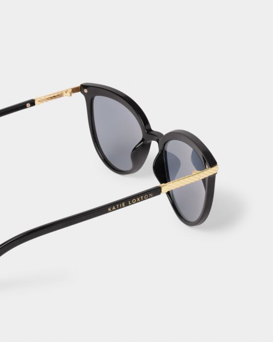 Black cat-eye Ravello Sunglasses with round UV400 lenses, gold arm detailing, "Katie Loxton" in gold. Sizes: standard.