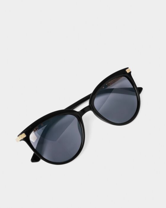 The Ravello Sunglasses in black have round frames, dark lenses, gold accents, UV400 protection. Available in 2 sizes.