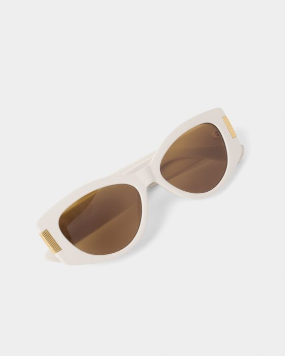 White Rimini Cat-Eye Sunglasses with brown lenses, gold accents, UV400 protection, recycled materials. Available in three sizes.