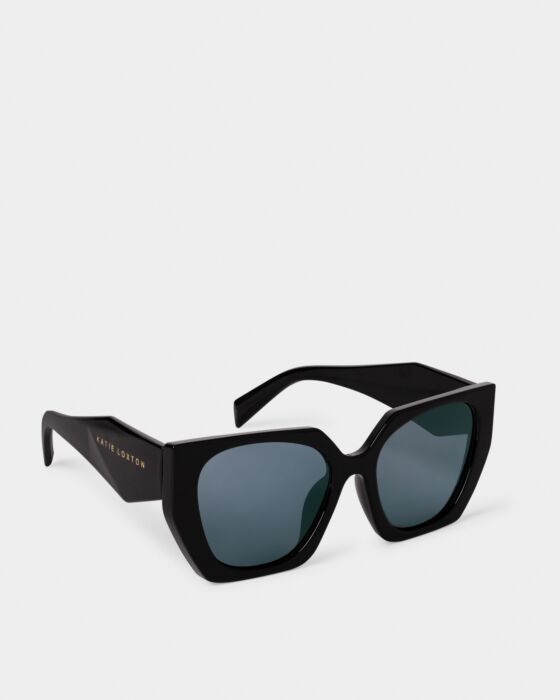 Corsica Sunglasses: thick square recycled frames, UV400 dark lenses, wide arms with "Katie Loxton" in gold. Sizes: S/M/L.