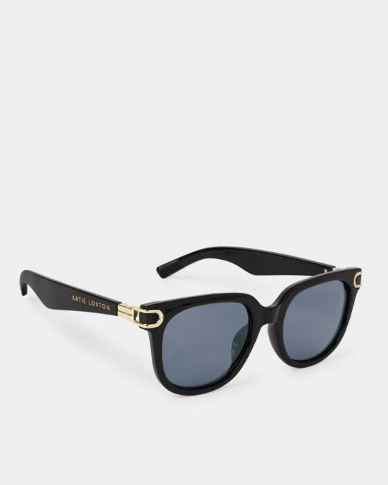 Manhattan Sunglasses: dark lenses, gold hinge accents, "Katie Loxton" branded arms, recycled materials, UV400. Sizes: one size.