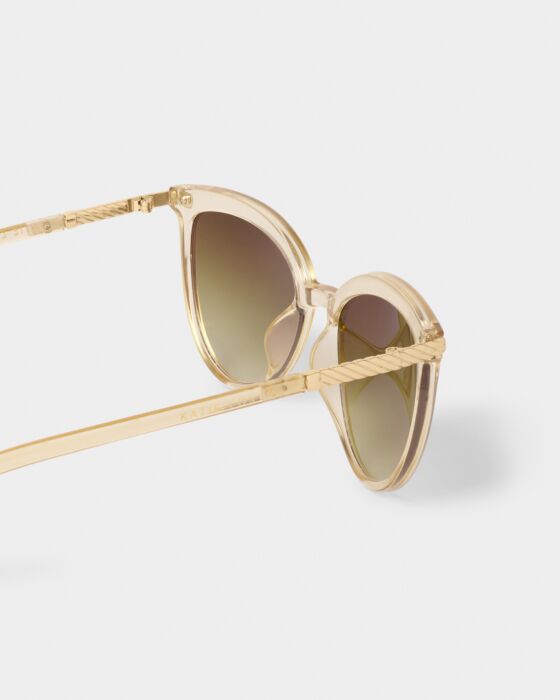 The Ravello Sunglasses in translucent beige have round gold-tinted frames, clear arms, UV400 gradient lenses. Sizes: S, M, L.