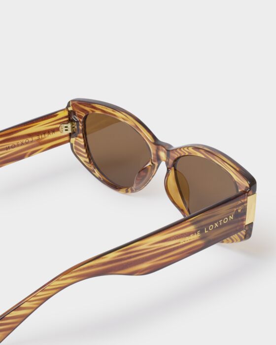 Rimini Cat-Eye Sunglasses in tortoiseshell with brown lenses, gold detailing, "LOXTON" on side. Sizes: S, M, L. 3 colors.