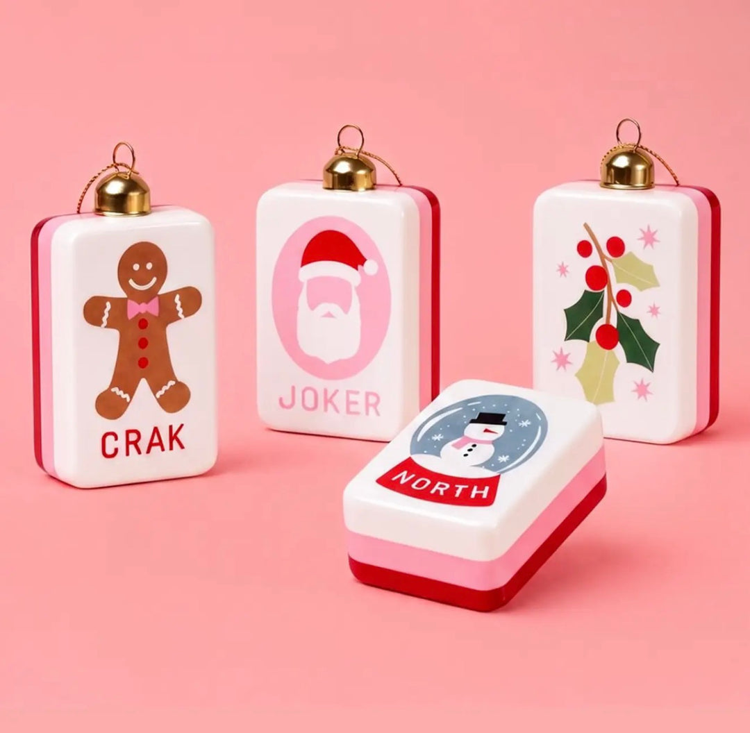 Four rectangular mahjong Christmas ornaments featuring gingerbread man, Santa, holly, and snowman designs, with gold hanging loops.