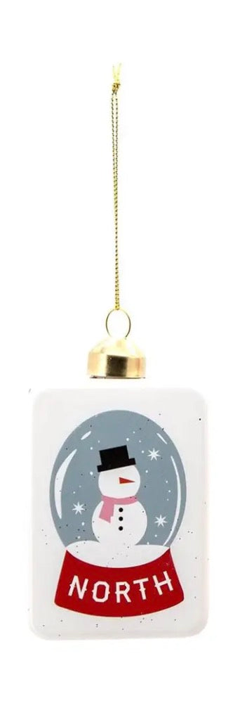 Rectangular mahjong tile ornament with a snow globe illustration of a snowman and the word “NORTH” on a red base.