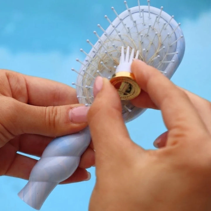 Mini Detangler Brush for Medium Hair by Tide &amp; True; available in mini size; pronged tool removes hair from the bristles.