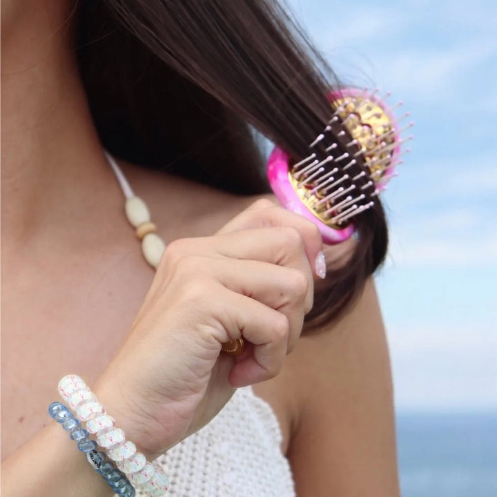 Pinch Me! Tie Dye Pink Vented Hair Brush brushing long brown hair. Available in small, medium, and large sizes.