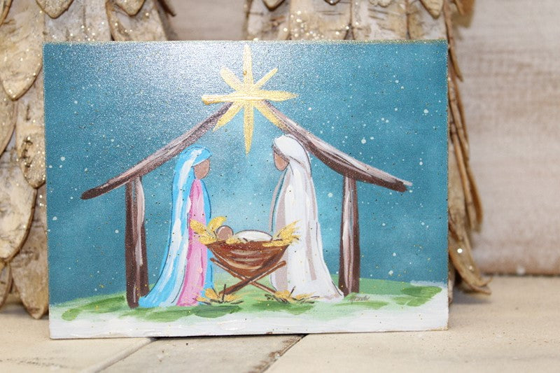 Small rectangular hand-embellished colorful Nativity table art with gold glitter, featuring a painted scene with a gold star above a manger.