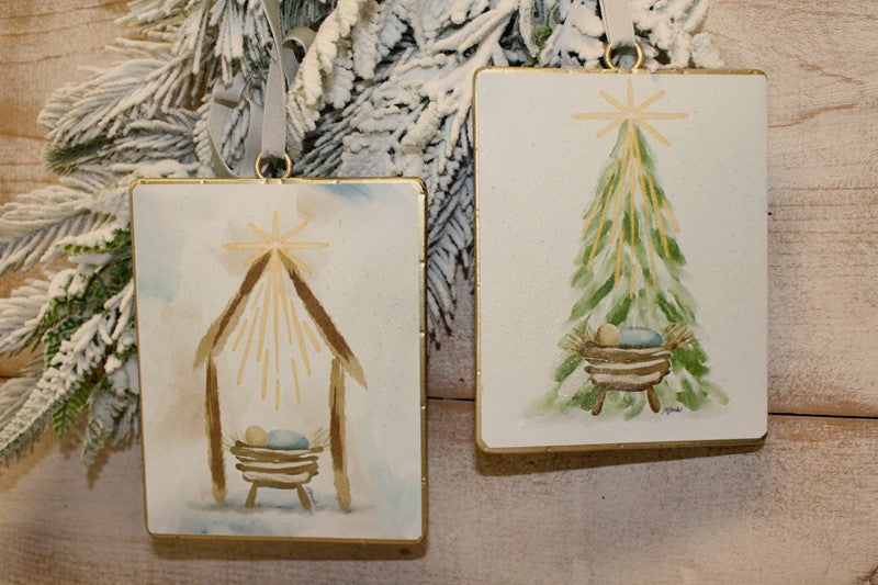 Two rectangular Glittered Baby Jesus in the Manger ornaments with gold rims, featuring a star scene and a Christmas tree scene.