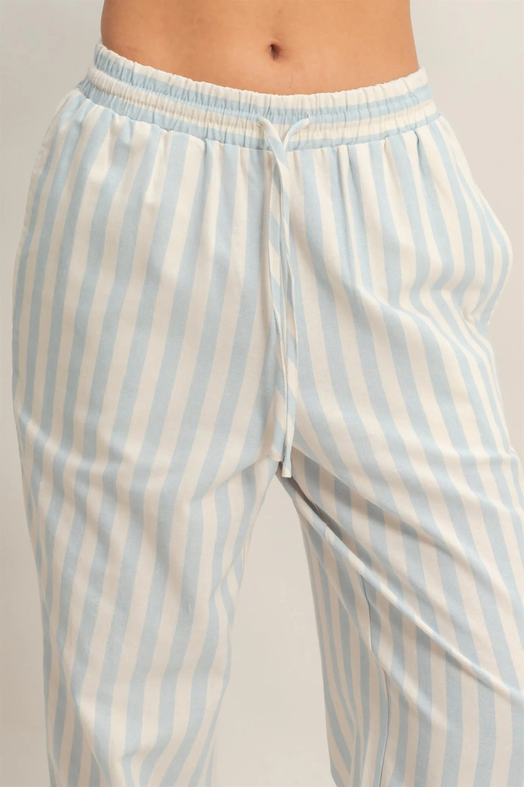 Blue vertical striped elastic pants with pockets, relaxed wide legs, light blue and white stripes. Available in S, M, L, XL.