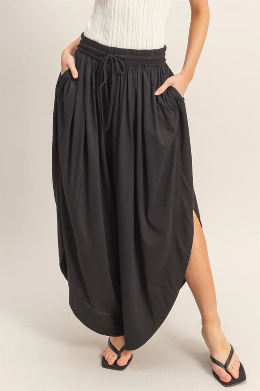 Tulip Hem Wide-Leg Pants in flowy knit with side pockets and drawstring waist. Available in sizes XS–XL.