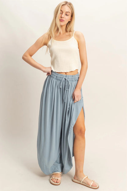 Tulip Hem Wide-Leg Pants in light blue with high slit and flowy knit fabric. Available in sizes XS–XL.