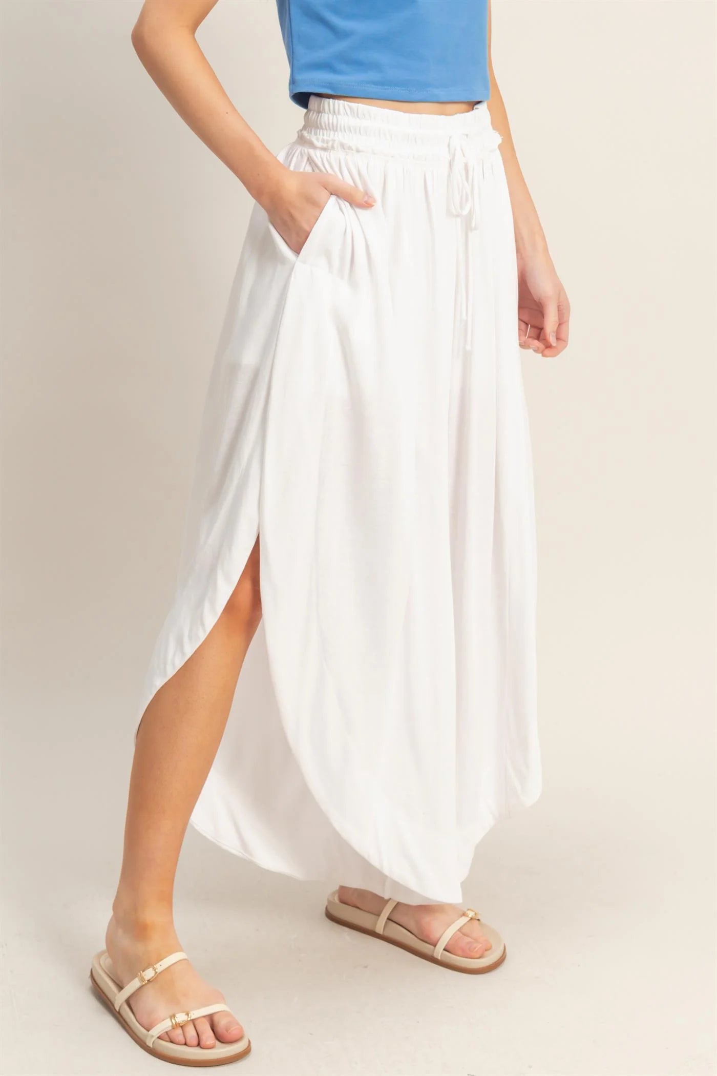 White Tulip Hem Wide-Leg Pants with side slits and pockets. Available in sizes XS–XL.
