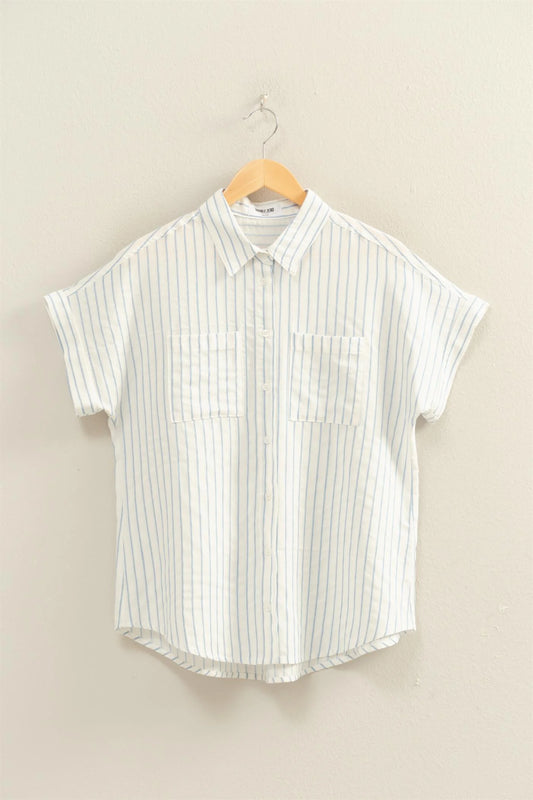 White shirt with blue vertical stripes, button-up, dolman sleeves, two chest pockets, relaxed fit. Available in S–XL.
