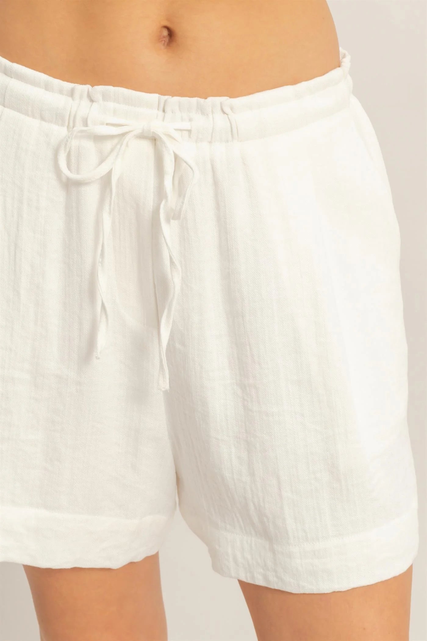 White linen drawstring pleated shorts with adjustable waist. Available in 2 colors and various sizes.