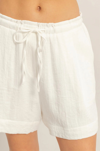 White linen drawstring pleated shorts with adjustable waist. Available in 2 colors and various sizes.