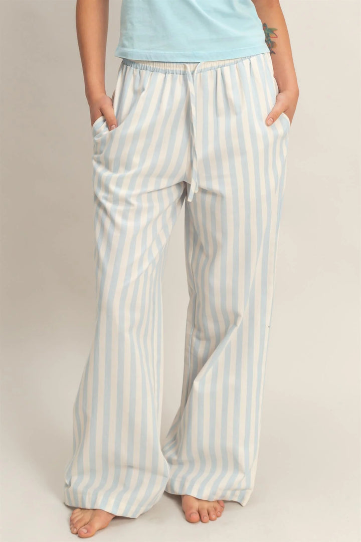 Blue vertical striped elastic pants with pockets, light blue and white stripes, relaxed fit. Sizes: S, M, L, XL.