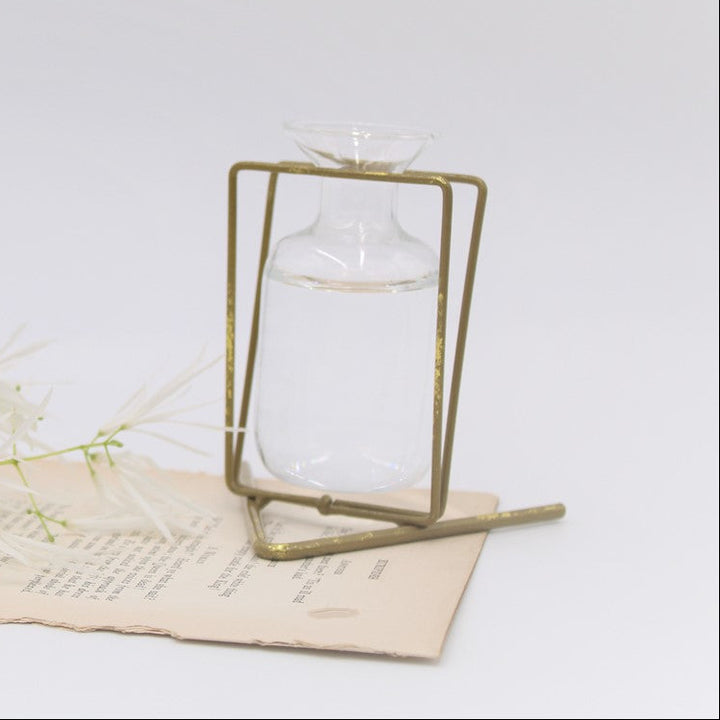 The 3.5" Metal Stand with Glass Vase in gold offers an elegant display, perfect for holding water and enhancing floral arrangements. Available size: 3.5 inches.
