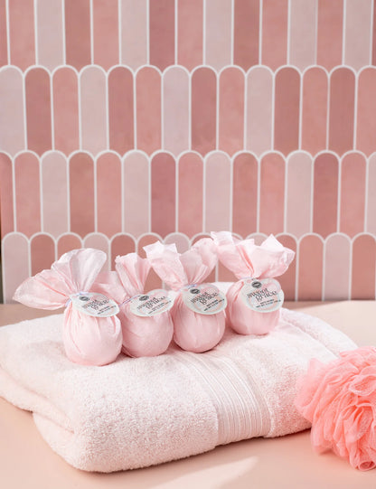 Four Sweet Grace Bath Bombs wrapped in tissue on a towel. Available sizes: set of 4 bath bombs.