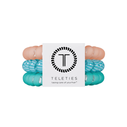 Three TELETIES Hair Ties—two teal/white striped, one solid peach. Available in small, medium, and large sizes.
