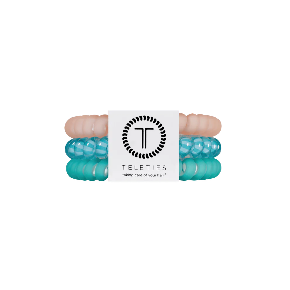 Three TELETIES Hair Ties in pastel pink, translucent turquoise, and opaque turquoise with white label. Available in small and large.