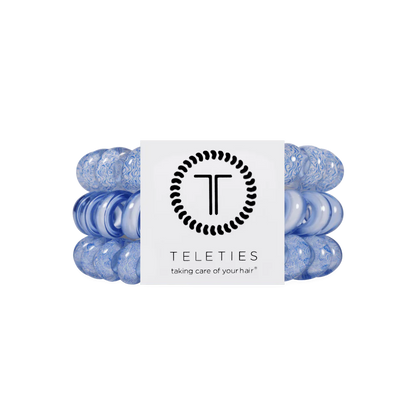 Pack of two blue TELETIES Hair Ties with "TELETIES" label and "taking care of your hair" tagline; available in multiple sizes.