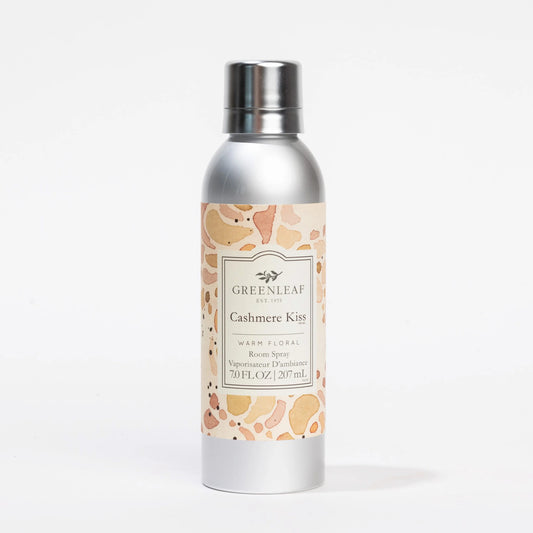 Cashmere Kiss Room Spray: silver canister, pink/peach/beige label, warm floral scent. Available in 7.0 FL OZ (207 mL).