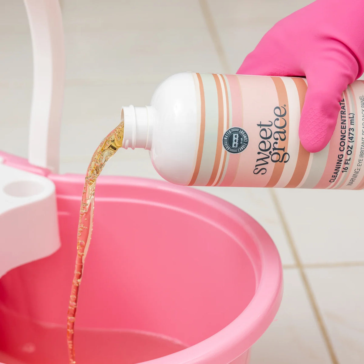 Sweet Grace Cleaning Concentrate bottle being poured; available in 8oz and 32oz sizes.