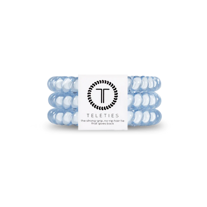 A chic set of light blue TELETIES coiled hair ties with a central white logo band, known for their strong grip and no-rip feature. Available in small and large sizes.