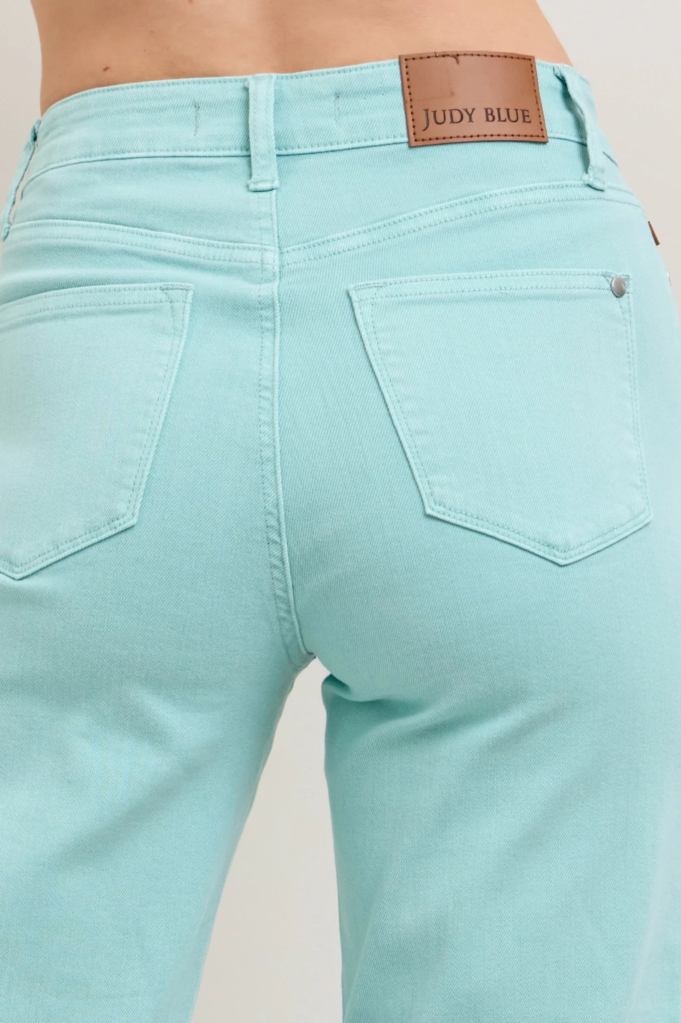 Judy Blue HW Garment Dyed Light Sky Blue Crop Wide Jeans feature two back pockets and a brown leather patch. Available in sizes 0-24.