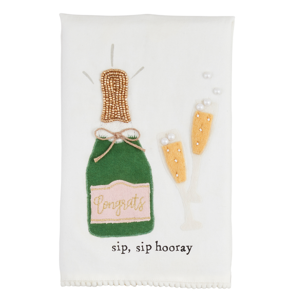 The Wedding Beaded Tea Towel is a premium cotton hand towel featuring an embroidered green champagne bottle labeled "Congrats," with two filled glasses, decorative trim, and the phrase "sip, sip hooray." Sizes available: One size.
