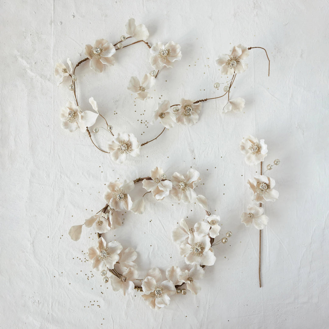 Blush faux magnolia flower garland and matching wreath with glitter, jewels, and beaded details.