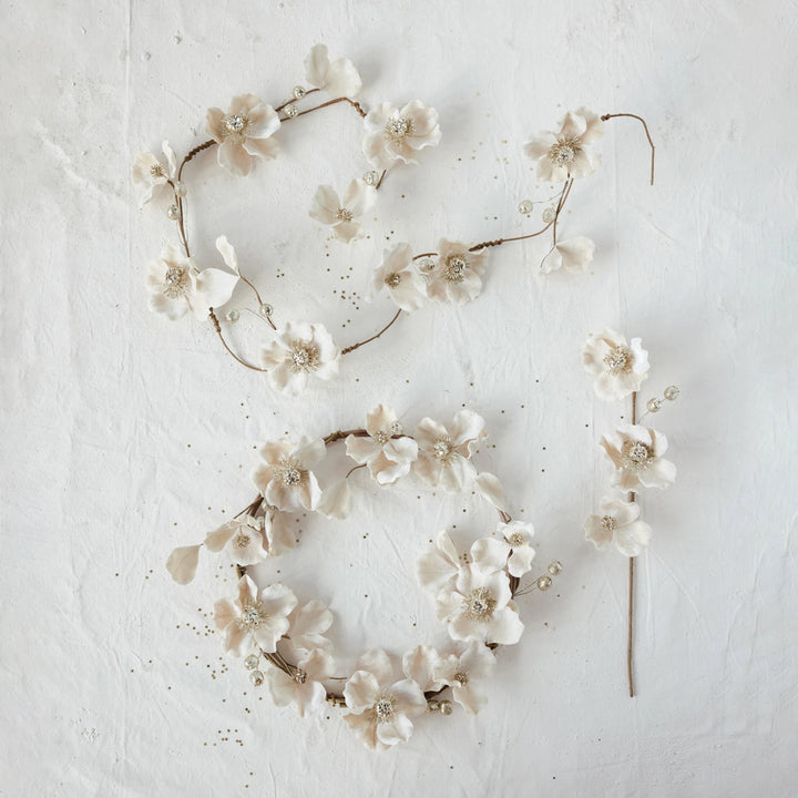 Blush faux magnolia flower garland and matching wreath with glitter, jewels, and beaded details.
