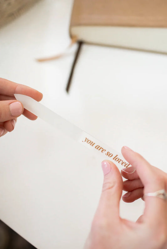 Translucent salon-quality glass nail file with gold 'you are so loved' text; available in standard and travel sizes.