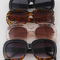 Rounded rectangular sunglasses in solid black, tortoiseshell, and clear frames. Sizes: S, M, L.