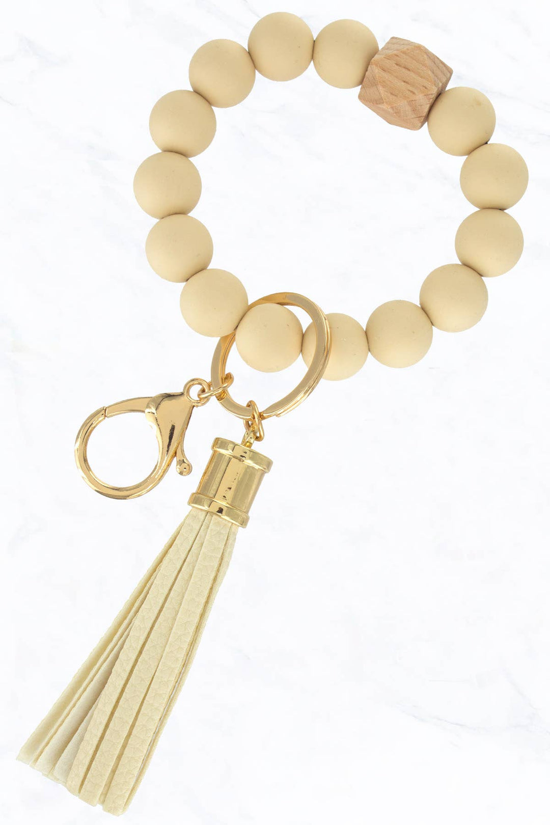 Beige silicone beaded keychain with gold ring, clasp, wooden bead, and beige tassel. Sizes: S, M, L.