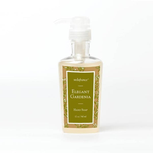 Elegant Gardenia" liquid hand soap is housed in a clear bottle for easy visibility of the soap level. A convenient pump dispenser ensures a mess-free usage. It has an eye-catching label adorned with shades of green and gold. The subtle, elegant scent of gardenias fills the air upon use. Available in various sizes to cater to your needs: small for occasional use or traveling, medium for regular use, and large size for heavy-duty or commercial use.