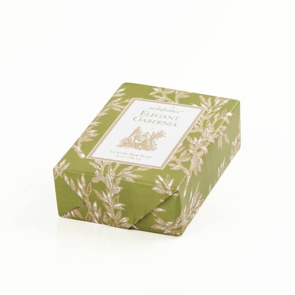 Elegant Gardenia Bar Soap from Seduire. Features a sweet, floral scent. Encased in an olive green paper with gold floral patterns. The soap bar size is standard; no specific sizes available for selection.