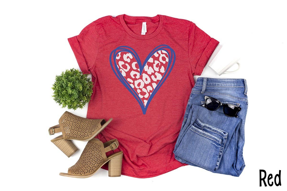 Patriotic Leopard Heart Red Tee with a blue-outlined heart and leopard print design on ultra-soft Bella Canvas fabric, available in unisex sizes S-XXL. "Red" appears in the bottom right corner.